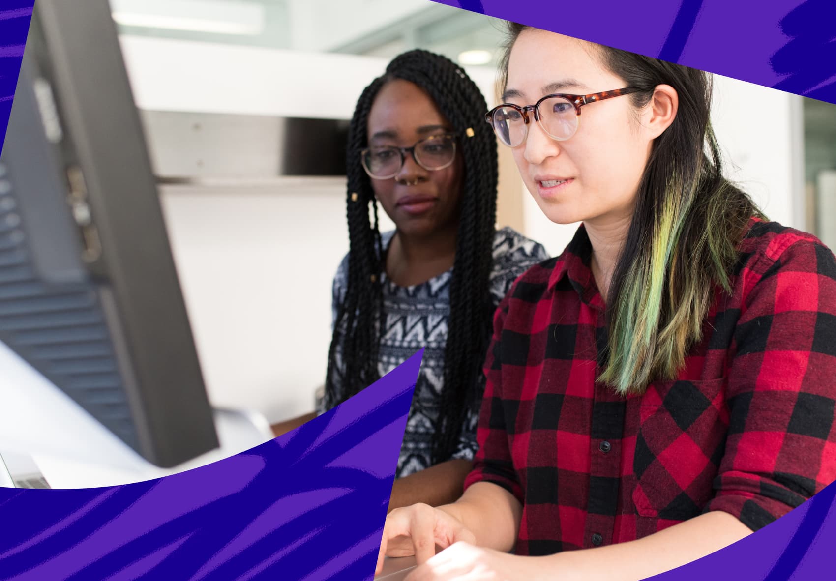 Two woman sitting in front of computer