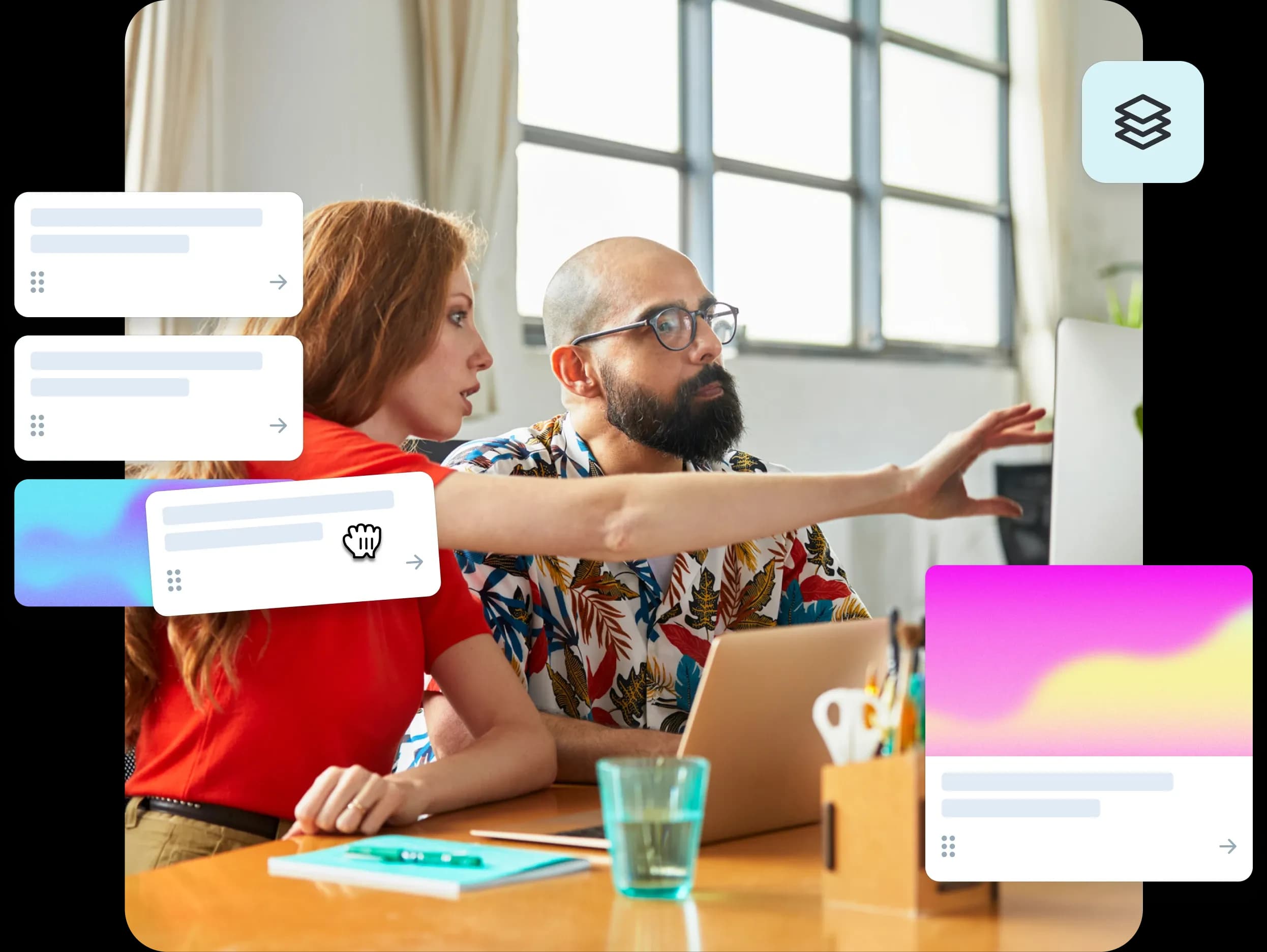 Two product managers at a desk, one pointing at a computer screen.